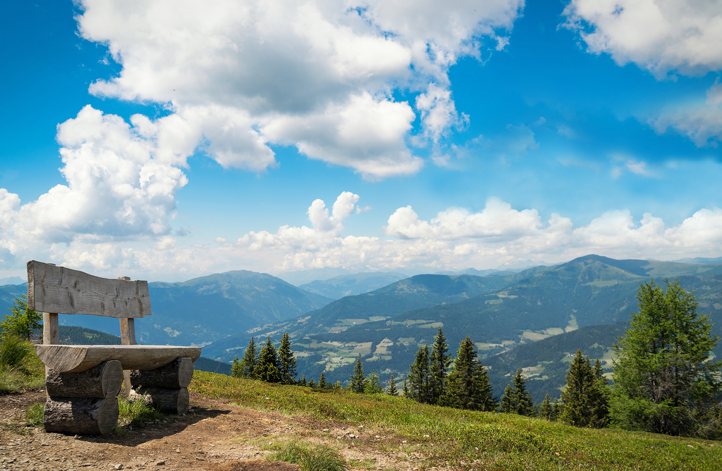 Eine hölzerne Bank lädt ein, den Blick auf Kärntens Berge zu genießen.