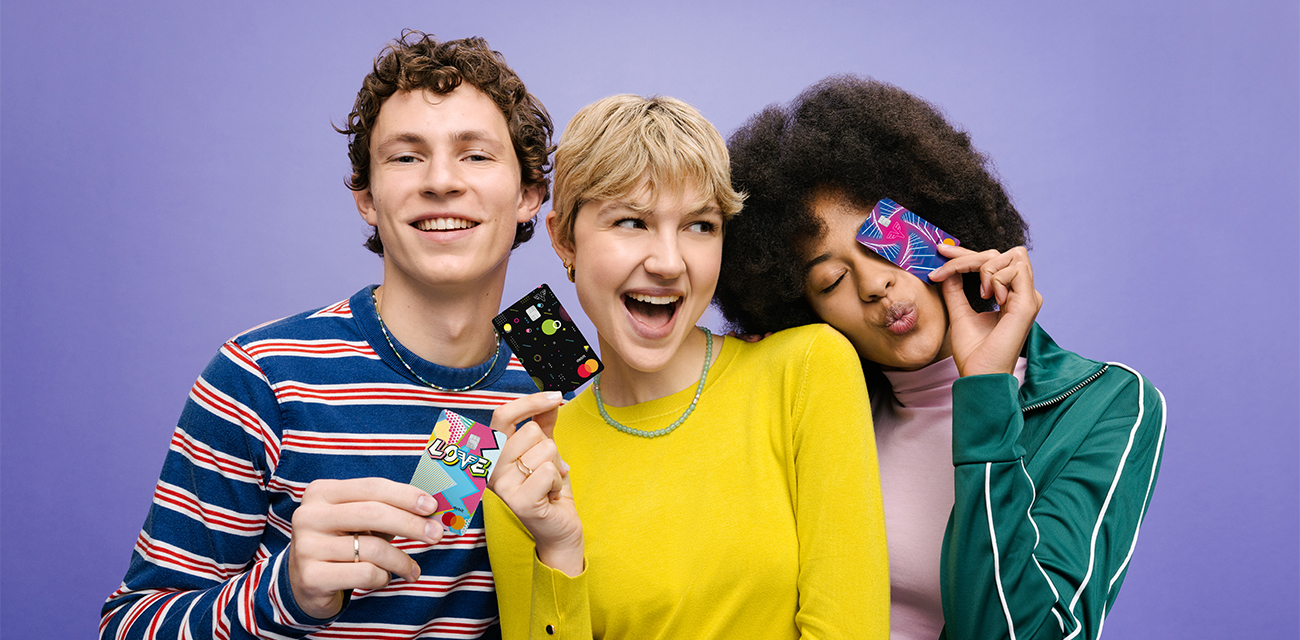 Dire Jugendliche mit strahlen und halten die drei Volksbank Debitkarten fröhlich in der Hand.