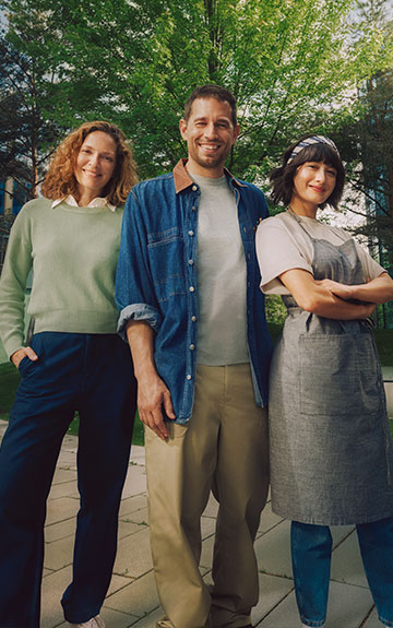 Ein Unternehmer und zwei Unternehmerinnen stehen nebeneinander. Sie blicken selbstbewusst in die Kamera.