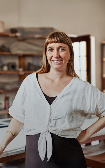 Eine Unternehmerin steht in ihrer Töpferei